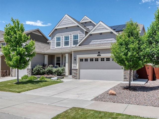 14565 Vancouver Pl, Parker, CO 80134 - craftsman-style house with stone siding, roof mounted solar panels, concrete driveway, a garage, and covered porch