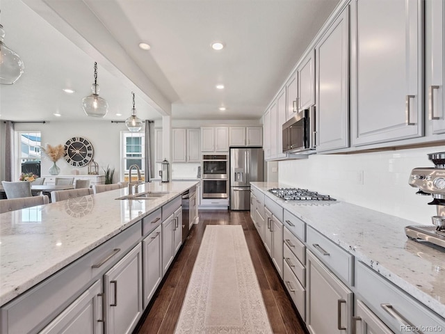 14565 Vancouver Pl, Parker, CO 80134 - kitchen with stainless steel appliances, recessed lighting, light stone counters, and dark wood finished floors