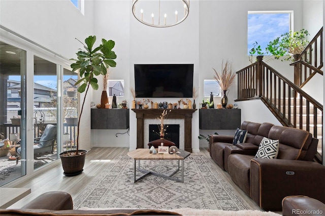 6454 Leathers Ln, Parker, CO 80134 - living area with wood finished floors, a fireplace, a chandelier, and stairs