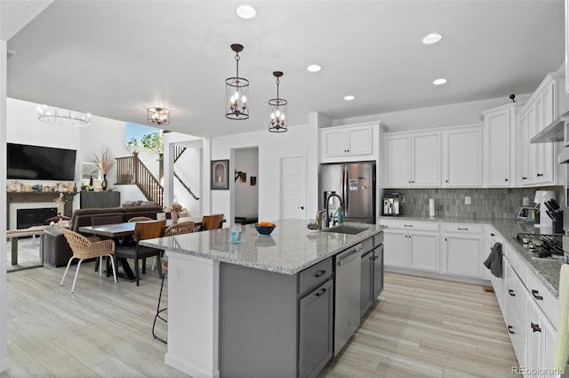 6454 Leathers Ln, Parker, CO 80134 - kitchen with appliances with stainless steel finishes, white cabinets, backsplash, open floor plan, and a chandelier