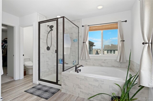 6454 Leathers Ln, Parker, CO 80134 - bathroom featuring a garden tub, a shower stall, wood finished floors, recessed lighting, and a spacious closet