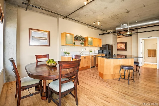 dining space with sink and light wood-type flooring