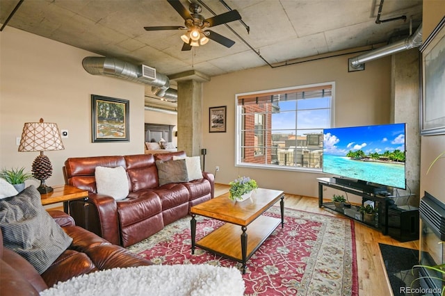 living room featuring decorative columns, ceiling fan, and light wood-type flooring