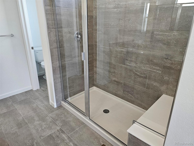 bathroom with a shower stall and toilet