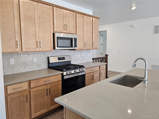 kitchen with stainless steel appliances, a sink, decorative backsplash, dark wood-style floors, and recessed lighting