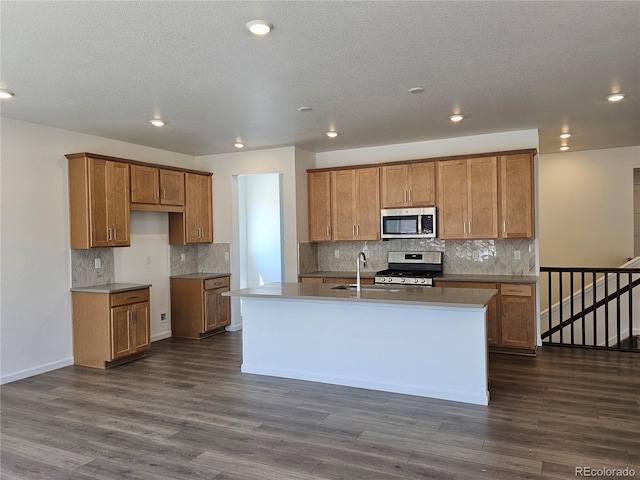 kitchen featuring stainless steel appliances, brown cabinetry, a sink, decorative backsplash, and recessed lighting