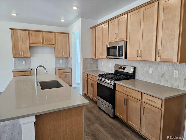 kitchen featuring appliances with stainless steel finishes, a sink, dark wood finished floors, light countertops, and recessed lighting