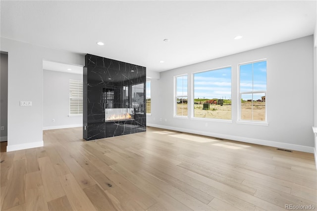 6683 Bridle Creek Pt, Castle Pines, CO 80108 - unfurnished living room with light wood-style flooring, a fireplace, and recessed lighting