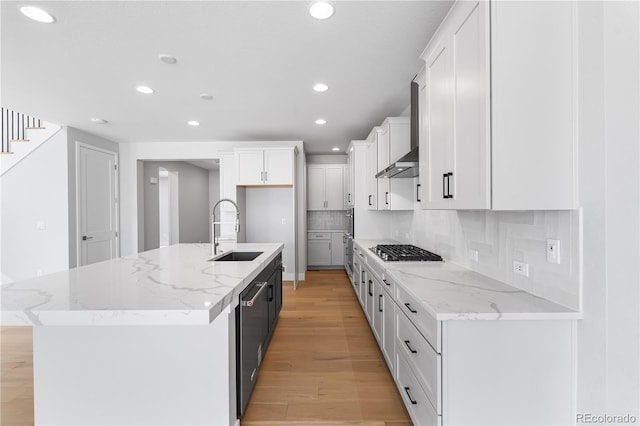 6683 Bridle Creek Pt, Castle Pines, CO 80108 - kitchen featuring recessed lighting, light wood-style floors, stainless steel appliances, white cabinets, and wall chimney range hood