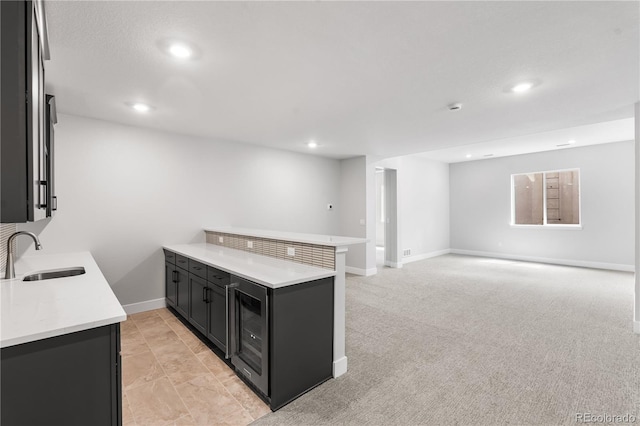 6683 Bridle Creek Pt, Castle Pines, CO 80108 - kitchen with a peninsula, light countertops, recessed lighting, dark cabinets, and wine cooler
