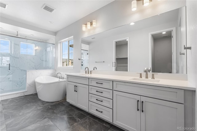 6683 Bridle Creek Pt, Castle Pines, CO 80108 - bathroom with a marble finish shower, double vanity, marble finish floors, a freestanding tub, and recessed lighting
