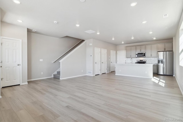 unfurnished living room featuring light hardwood / wood-style floors and sink