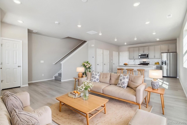 living room featuring sink and light wood-type flooring