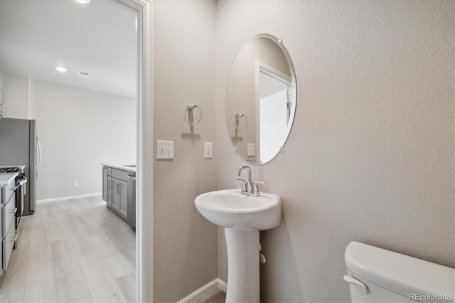 bathroom with toilet and wood-type flooring