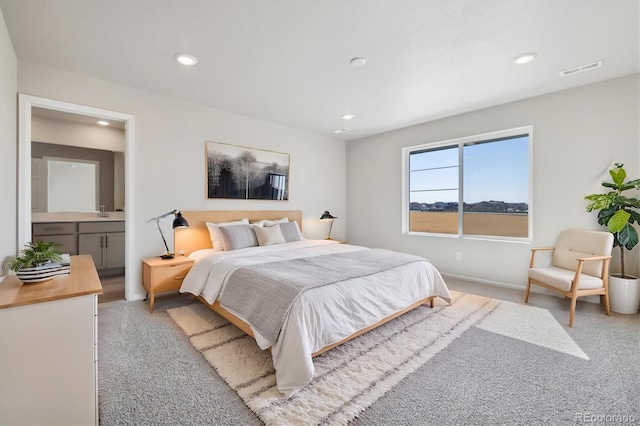 bedroom with light carpet and ensuite bath