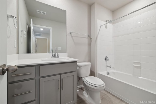 full bathroom featuring tiled shower / bath, vanity, and toilet