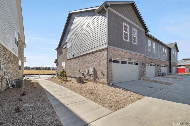 view of side of property with a garage and central AC unit