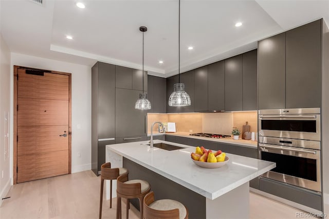 1901 Wazee St Unit 707, Denver, CO 80202 - kitchen featuring modern cabinets, stainless steel appliances, light wood-type flooring, a center island with sink, and recessed lighting