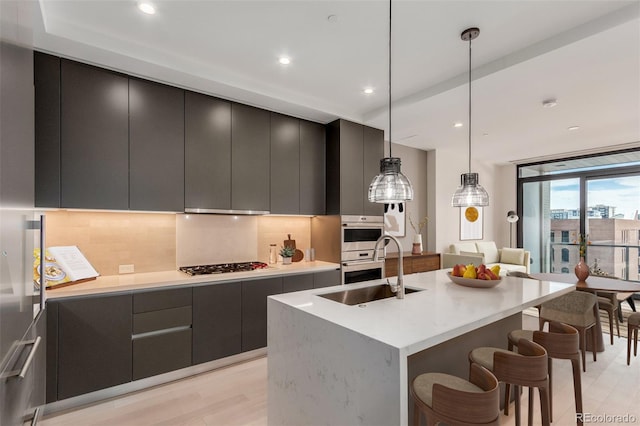 1901 Wazee St Unit 707, Denver, CO 80202 - kitchen with modern cabinets, stainless steel appliances, backsplash, a breakfast bar, and light wood-style floors