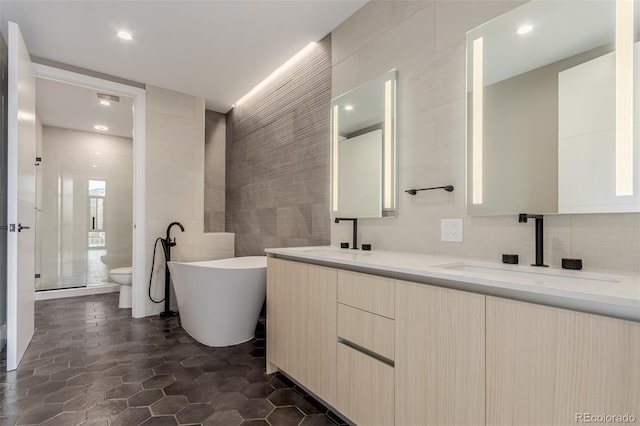 1901 Wazee St Unit 707, Denver, CO 80202 - full bath featuring tile walls, double vanity, a freestanding tub, a stall shower, and recessed lighting