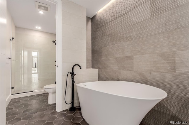 1901 Wazee St Unit 707, Denver, CO 80202 - full bathroom featuring tile walls, tile patterned flooring, a freestanding tub, and a stall shower