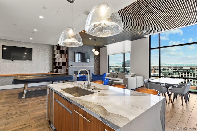 1901 Wazee St Unit 707, Denver, CO 80202 - kitchen featuring open floor plan, brown cabinets, light wood-style flooring, floor to ceiling windows, and a center island with sink