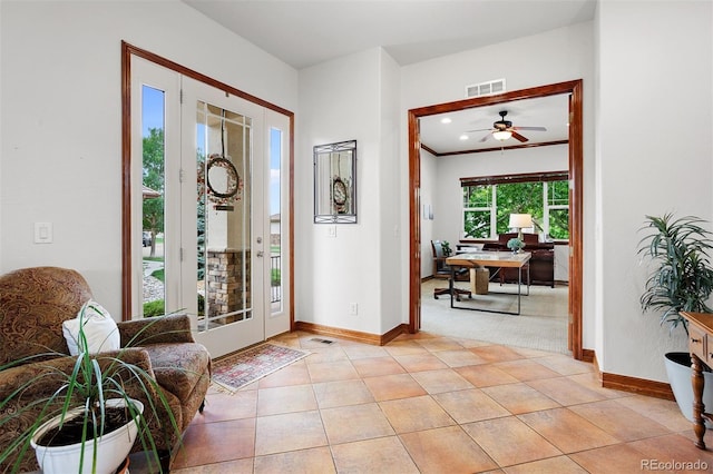 tiled entryway with ceiling fan and plenty of natural light