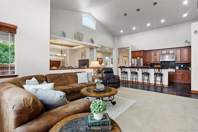 living room with dark hardwood / wood-style flooring, high vaulted ceiling, and a chandelier