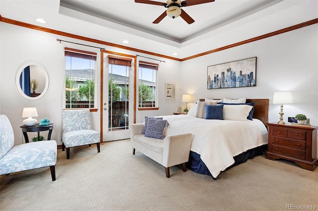 carpeted bedroom featuring access to exterior, ceiling fan, and a raised ceiling