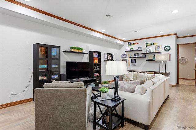 living room with ornamental molding and light hardwood / wood-style floors