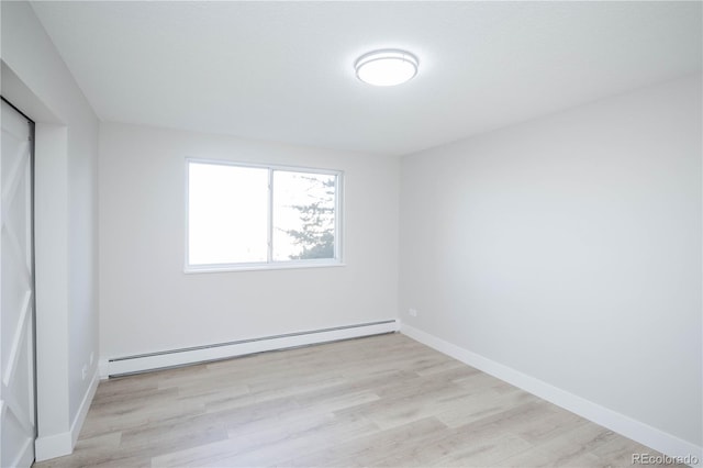 9155 E Center Ave Unit 4B, Denver, CO 80247 - unfurnished bedroom featuring a baseboard radiator and wood finished floors