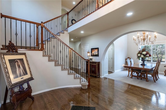 foyer with hardwood / wood-style flooring and a towering ceiling