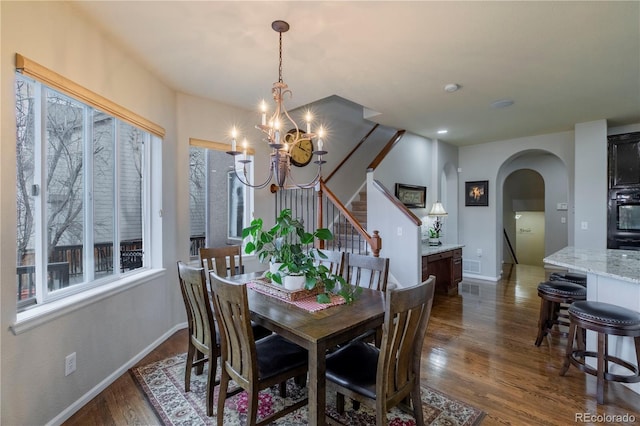 dining area featuring an inviting chandelier and dark hardwood / wood-style flooring