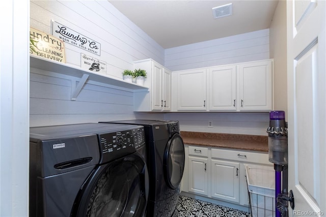 laundry room with cabinets, separate washer and dryer, and wooden walls