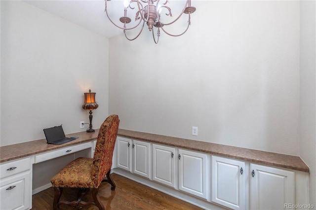 office space featuring dark hardwood / wood-style floors, built in desk, and a notable chandelier