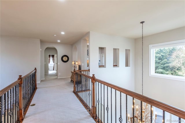 hall with a chandelier and carpet