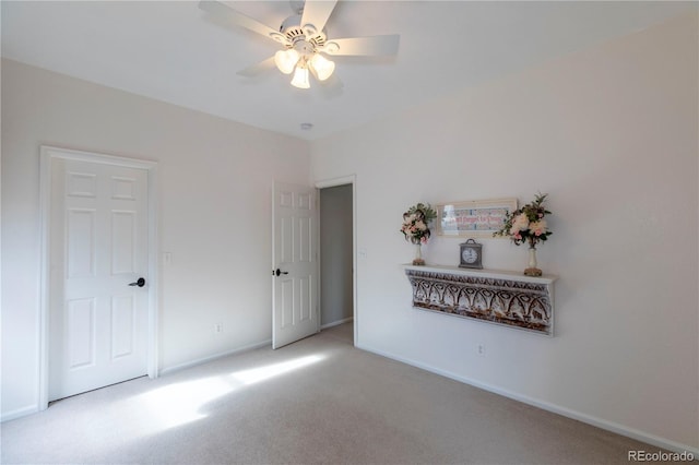 carpeted spare room featuring ceiling fan