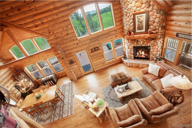 514 Little Baldy Cir, Fairplay, CO 80440 - living room with rustic walls, hardwood / wood-style floors, a stone fireplace, and a high ceiling