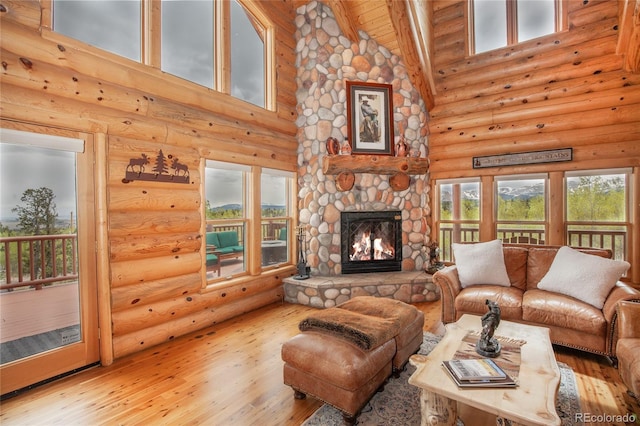 514 Little Baldy Cir, Fairplay, CO 80440 - living room with rustic walls, high vaulted ceiling, hardwood / wood-style floors, a stone fireplace, and plenty of natural light