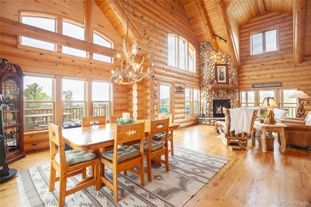514 Little Baldy Cir, Fairplay, CO 80440 - dining room with high vaulted ceiling, log walls, a stone fireplace, light wood-style floors, and wooden ceiling with exposed beams