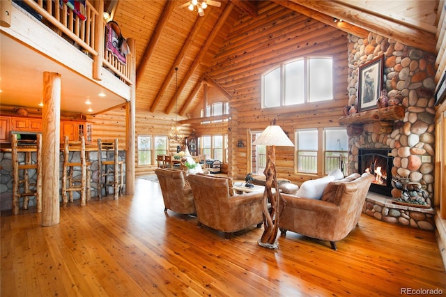514 Little Baldy Cir, Fairplay, CO 80440 - living area featuring rustic walls, high vaulted ceiling, hardwood / wood-style floors, a stone fireplace, and wooden ceiling with exposed beams