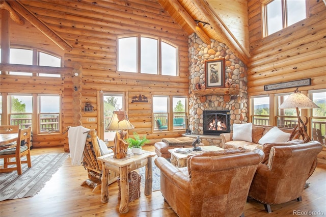 514 Little Baldy Cir, Fairplay, CO 80440 - living area featuring high vaulted ceiling, log walls, light wood-type flooring, a fireplace, and wood ceiling with exposed beams