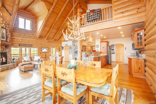 514 Little Baldy Cir, Fairplay, CO 80440 - dining room featuring high vaulted ceiling, arched walkways, log walls, light wood-type flooring, and a fireplace