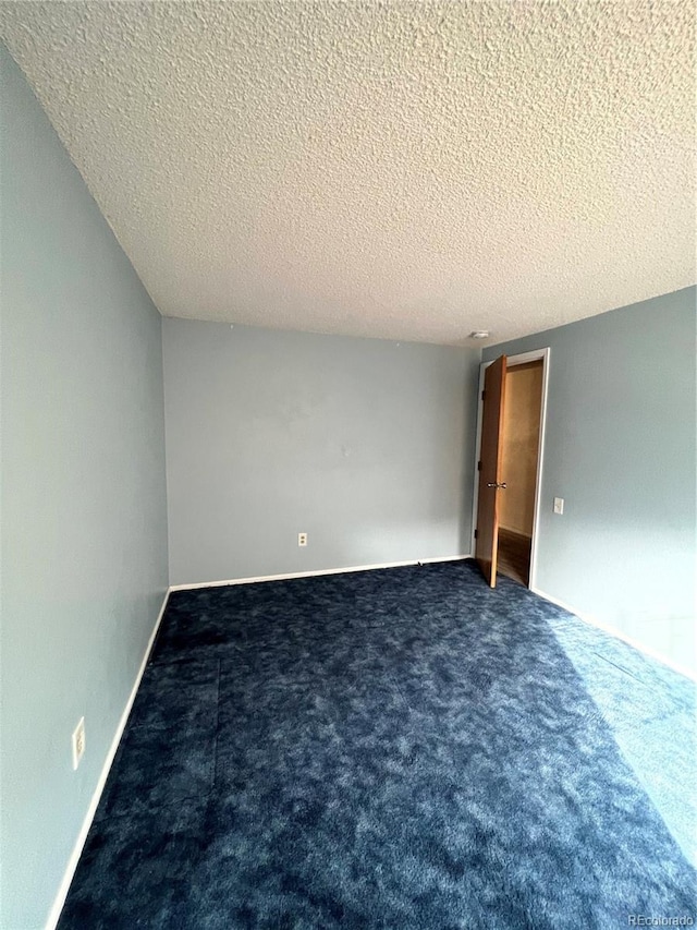 carpeted spare room with baseboards and a textured ceiling