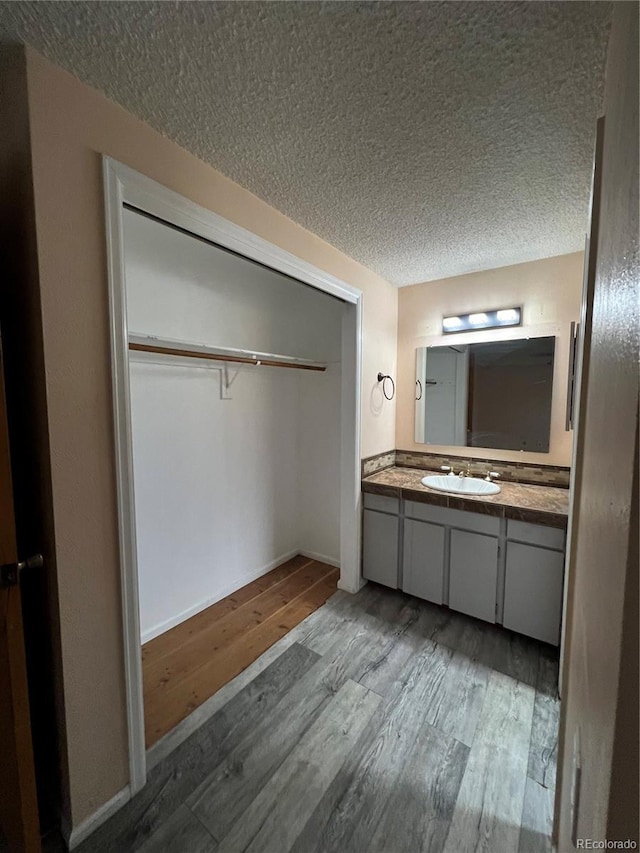 bathroom with vanity, a textured ceiling, and wood finished floors