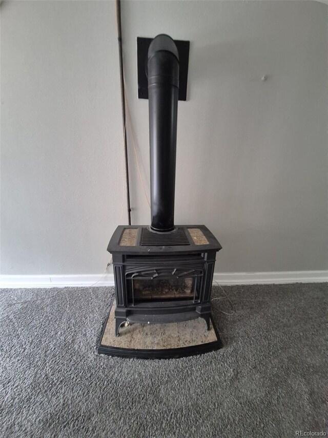 2758 S Salida St, Aurora, CO 80013 - detailed view of carpet flooring, a wood stove, and baseboards