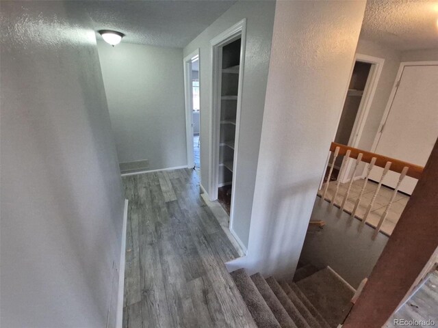 2758 S Salida St, Aurora, CO 80013 - corridor featuring a textured ceiling, wood finished floors, and stairway