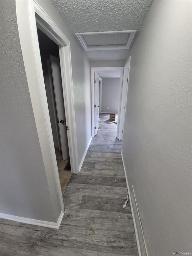 2758 S Salida St, Aurora, CO 80013 - corridor featuring attic access, wood finished floors, a textured ceiling, and baseboards