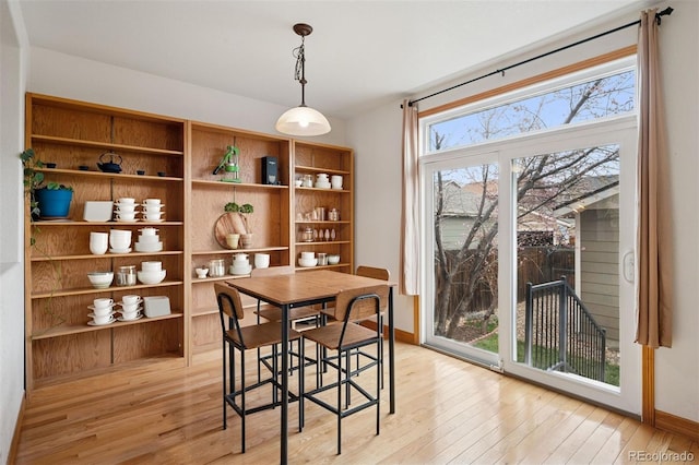 dining space featuring light wood finished floors and baseboards