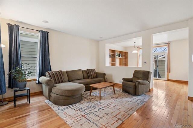 living area featuring baseboards and light wood-style floors